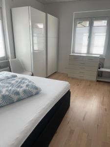 ein Schlafzimmer mit einem Bett, zwei Fenstern und einer Kommode in der Unterkunft Ferienwohnung Diana und Manuel in Weinheim