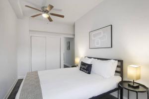 a bedroom with a white bed and a ceiling fan at 2BR Cozy and Furnished Apt in Hyde Park - Hyde Park 405 in Chicago
