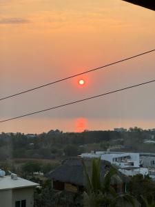 een uitzicht op de zonsondergang vanaf het dak van een huis bij Casa Terranova in Puerto Escondido