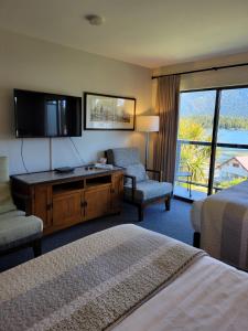 a hotel room with two beds and a flat screen tv at Tofino Motel Harborview in Tofino