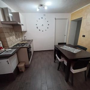 uma cozinha com uma mesa e um relógio na parede em B&B Biancamano em Maierà