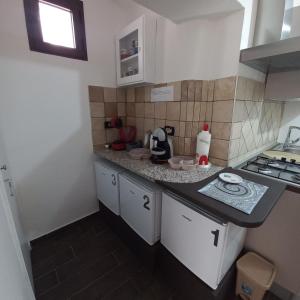 a small kitchen with white cabinets and a counter top at B&B Biancamano in Maierà