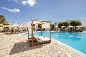 uma piscina do hotel com uma cadeira e uma cama em frente em Asteras Paradise em Naousa