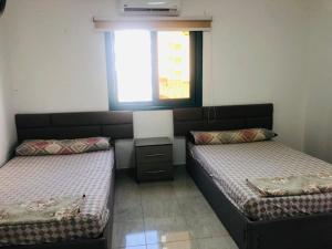 a bedroom with two beds and a window at Paradise Gates Golden Beach two in Ras Sedr