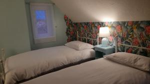 two beds in a room with a wall mural at Merrilees B&B in Holland-on-Sea