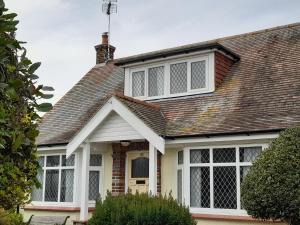 a house with white windows and a roof at Merrilees B&B in Holland-on-Sea