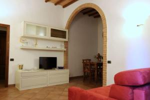 - un salon avec un canapé et une télévision dans l'établissement “Il Nespolino” Tuscan Country House, à Sienne
