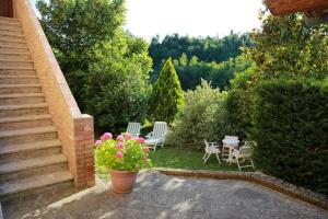 une terrasse avec des chaises, une table et des fleurs dans l'établissement “Il Nespolino” Tuscan Country House, à Sienne