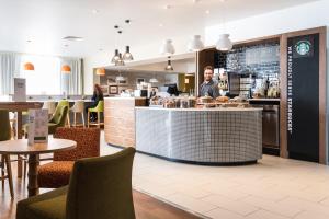 a man standing at the counter of a restaurant at Holiday Inn Brighton Seafront by IHG in Brighton & Hove