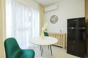 a dining room with a table and chairs and a clock at Himson Stylish Studio-Self Check-in near Airport & Mall in Iaşi