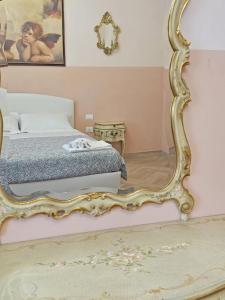 a bedroom with a bed and a large mirror at De' Bardi apartment x 6 in Florence