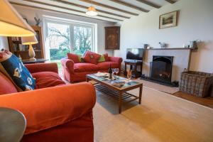 sala de estar con sofás rojos y chimenea en The Longhouse, en Pwllheli