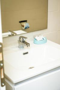 een wastafel in de badkamer met een kraan en een spiegel bij B&B Paradise in Napels