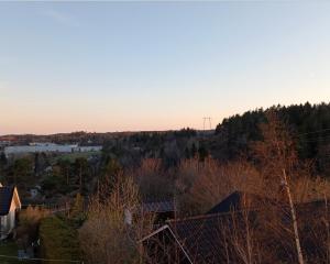 Blick auf eine Stadt mit Bäumen und den Sonnenuntergang in der Unterkunft Spacious 2 Bedroom Apartment in Arendal. in Arendal