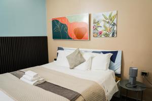 een slaapkamer met een bed en twee schilderijen aan de muur bij B&B Paradise in Napels