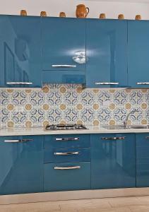 una cocina azul con armarios azules y azulejos en la pared en De' Bardi apartment x 6, en Florencia