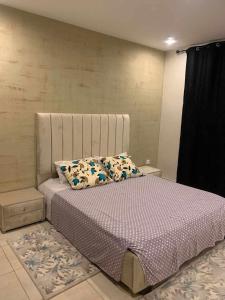 een slaapkamer met een bed met een hoofdeinde bij Résidence Hassan promo el menzeh canastel Oran in Oran
