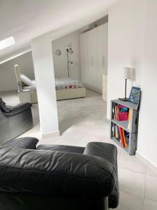 Una sala de estar con un sofá negro y una cama. en AriMAnd House, en La Spezia