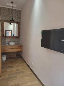 ein Bad mit einem Flachbild-TV an der Wand in der Unterkunft Villa Soudan in Bobo-Dioulasso