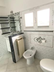 a white bathroom with a toilet and a sink at AriMAnd House in La Spezia