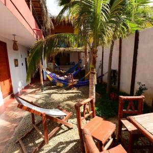 a patio with a hammock and a palm tree at Casa Máncora Guesthouse in Máncora