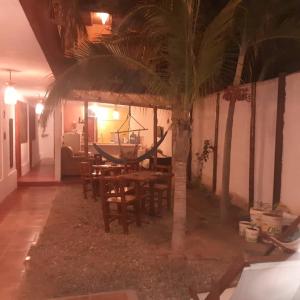 a dining room with a table and a palm tree at Casa Máncora Guesthouse in Máncora