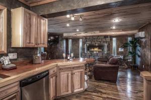 eine Küche mit Holzschränken und ein Wohnzimmer in der Unterkunft Redwood in the Historic Upper Canyon in Ruidoso