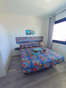 a bedroom with a bed with a colorful comforter at Vista Playa Blanca in Puerto del Rosario