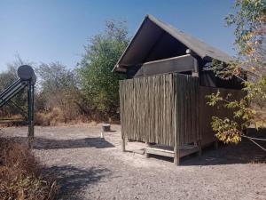 a wooden outhouse with a camera next to it at Hyenas howl campsite in Muchenje