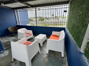 聖胡安的住宿－Urban Tropical Oasis in San Juan，阳台配有白色藤椅和桌子