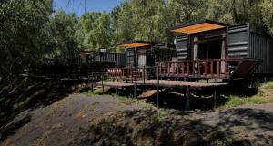 a resort cabin with a porch and a deck at Cabañas Borde Río Jacussi in Concepción