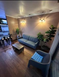 a living room with a blue couch and a table at Cabañas Borde Río Jacussi in Concepción