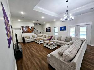 a living room with a couch and a table at Louisiana 5BR Luxury Pool Retreat in Lake Charles