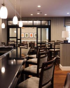 a restaurant with chairs and tables and a bar at The Centennial Hotel in Concord