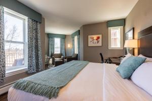 a bedroom with a bed and a desk and a window at The Centennial Hotel in Concord +84 photos