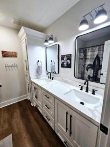 a bathroom with two sinks and a large mirror at Louisiana 5BR Luxury Pool Retreat in Lake Charles