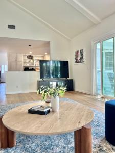 a living room with a table and a tv at Rose Garden Home, Entire 4bdr 2bth House with Offices, Thousand Oaks in Thousand Oaks