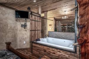 baño con bañera grande y TV. en SneakAway- in the Historic Upper Canyon!, en Ruidoso