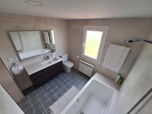 y baño con bañera, lavabo y aseo. en Casa da Riba da Lama Niñons ,Costa da Morte, en Ponteceso