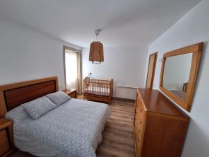 a bedroom with a bed and a dresser and a mirror at Casa tradicional en el Camino dos Faros Costa da Morte in Ponteceso