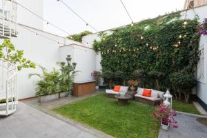 a garden with a couch and a green hedge at Casa Cáceres in Lima