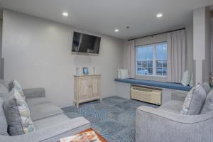 a living room with two couches and a tv at Microtel Inn & Suites by Wyndham Albertville in Albertville