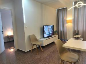 a living room with a tv and two chairs at Nefeli -1BR Lux Apartment - Tsimiski Ladadika - Explore Center by foot - Close to Aristotelous square in Thessaloniki