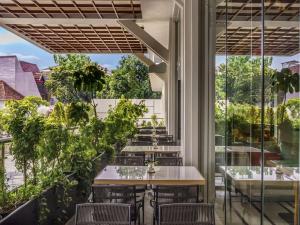 a restaurant with tables and chairs on a balcony at ibis Jakarta Raden Saleh in Jakarta