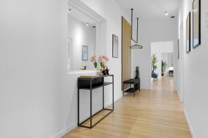 um corredor com paredes brancas e um longo corredor com uma mesa em OLIVE Apartments - 86m2 - Kingsize - Free Parking em Hanôver