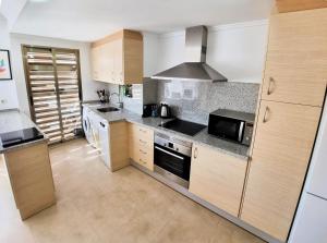 a kitchen with wooden cabinets and a stove top oven at Apartamento Miró in Calpe