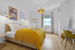 OLIVE Apartments - 86m2 - Kingsize - Free Parking في هانوفر: غرفة نوم بسرير وبطانية صفراء