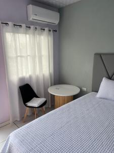 a bedroom with a bed and a chair and a table at Casa monte sion in Nueva San Salvador