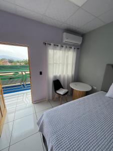 a bedroom with a bed and a table and a window at Casa monte sion in Nueva San Salvador