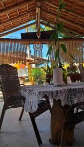 a table with a white lace table cloth on it at ITAÚNAS Pousada NOSSA PALHOÇA 1 in Itaúnas